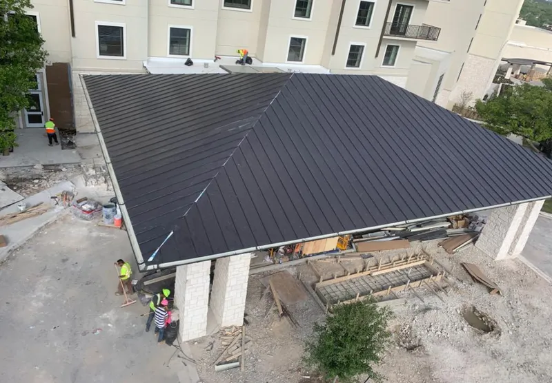 Metal roofing installation team working on a commercial building in North Canton